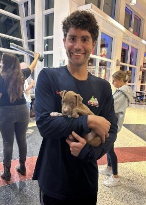 Arizona student-athlete smiling with a puppy